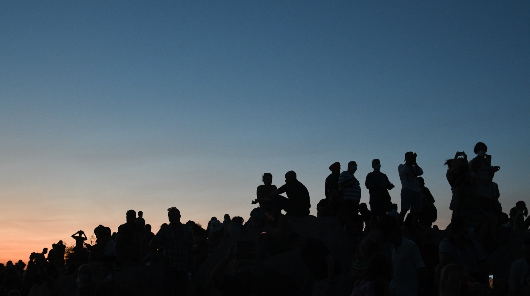 Κόσμος απολαμβάνει τη θέα στην Αθήνα από τον βράχο του Άρειου Πάγου