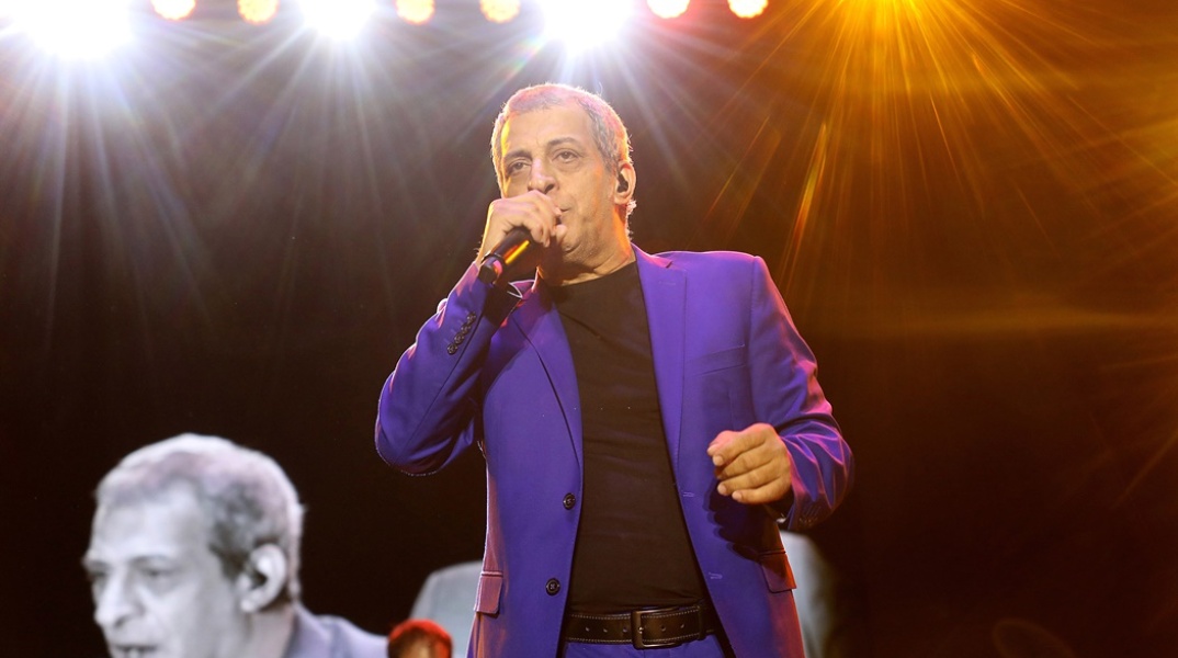 Ο Θέμης Αδαμαντίδης τραγουδά στη σκηνή και κρατά το μικρόφωνο