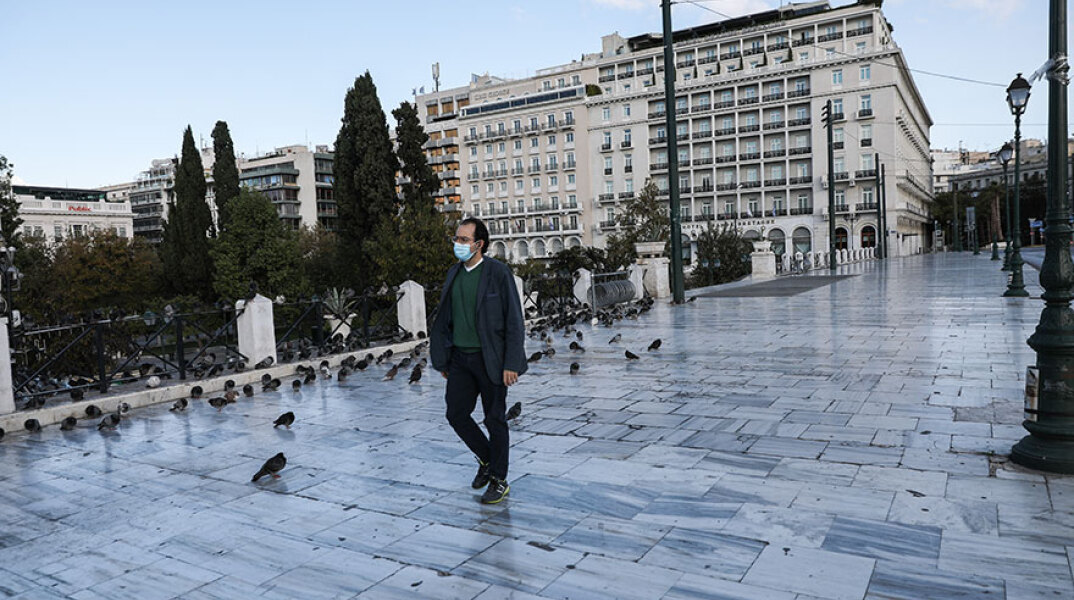 Lockdown: Πολίτης με μάσκα περπατά στην πλατεία Συντάγματος