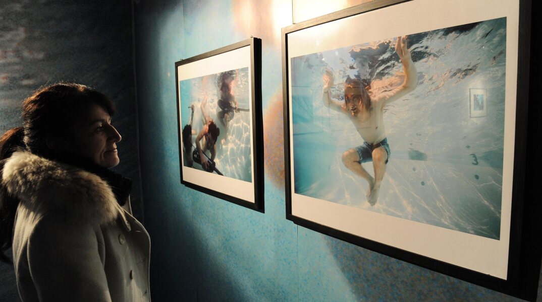 Γυναίκα που κοιτά φωτογραφίες σε έκθεση για τους Nirvana