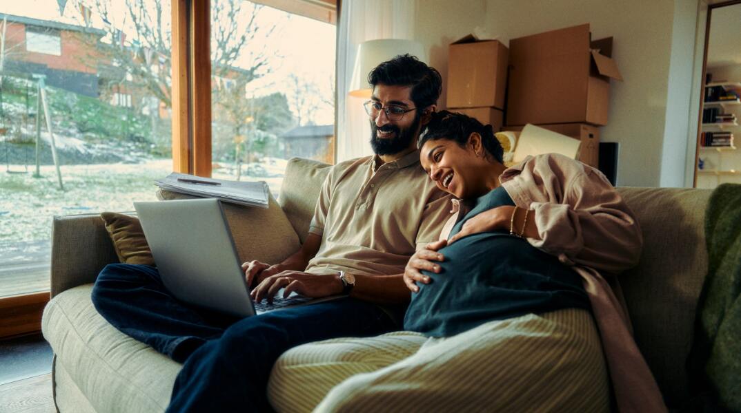 Άνδρας με έγκυο γυναίκα κοιτούν laptop