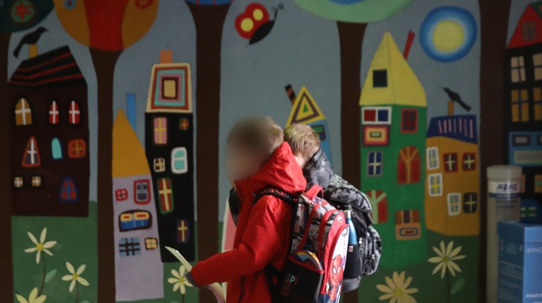 Παιδιά με τις σχολικές τους τσάντες στην πλάτη σε διάδρομο σχολείου