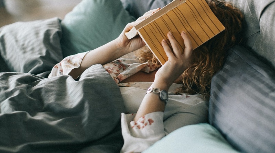 woman-covering-face-with-book-on-bed-1524232.jpg