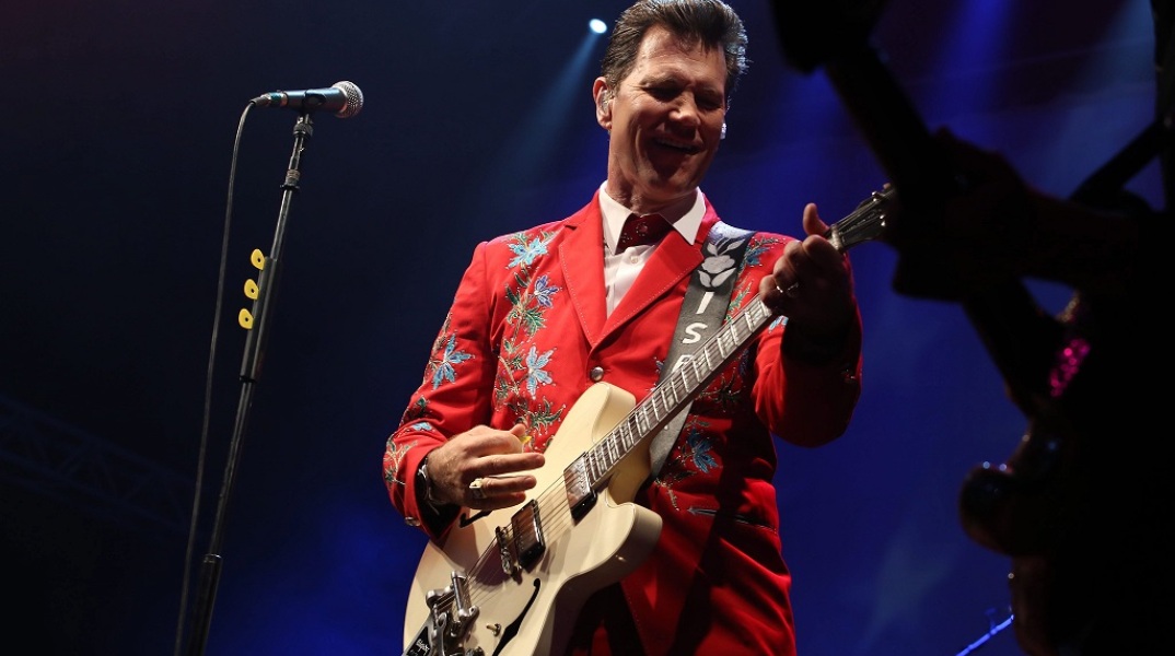 O Chris Isaak παίζει κιθάρα στη σκηνή