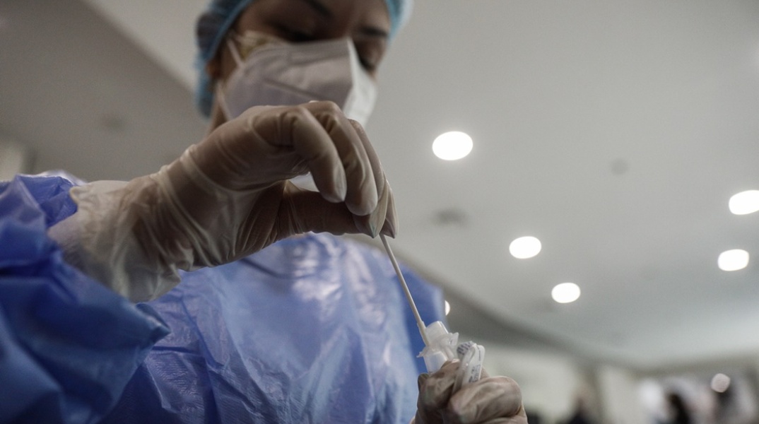 Γυναίκα κρατά στα χέρια της το υγρό και το στιλέο για rapid test