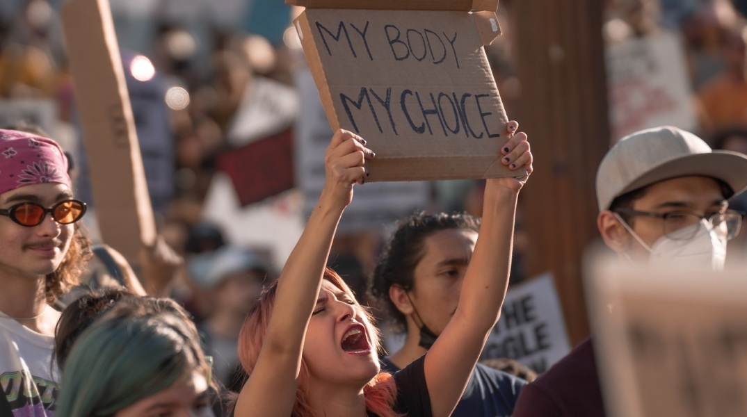 Γυναίκα με πλακάτ σε διαμαρτυρία για τις αμβλώσεις