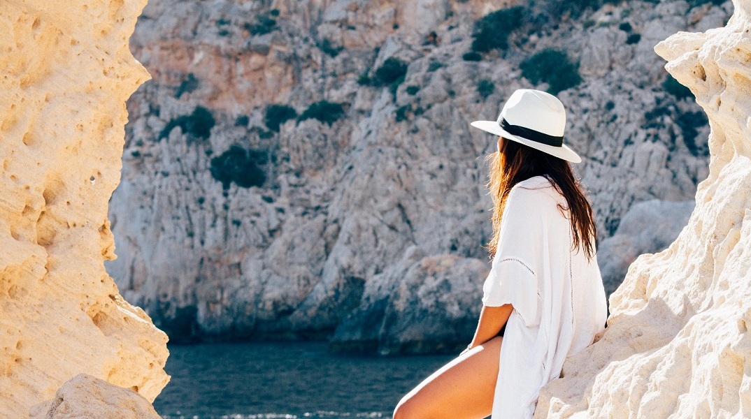 Ένα κορίτσι στα βράχια της παραλίας. 