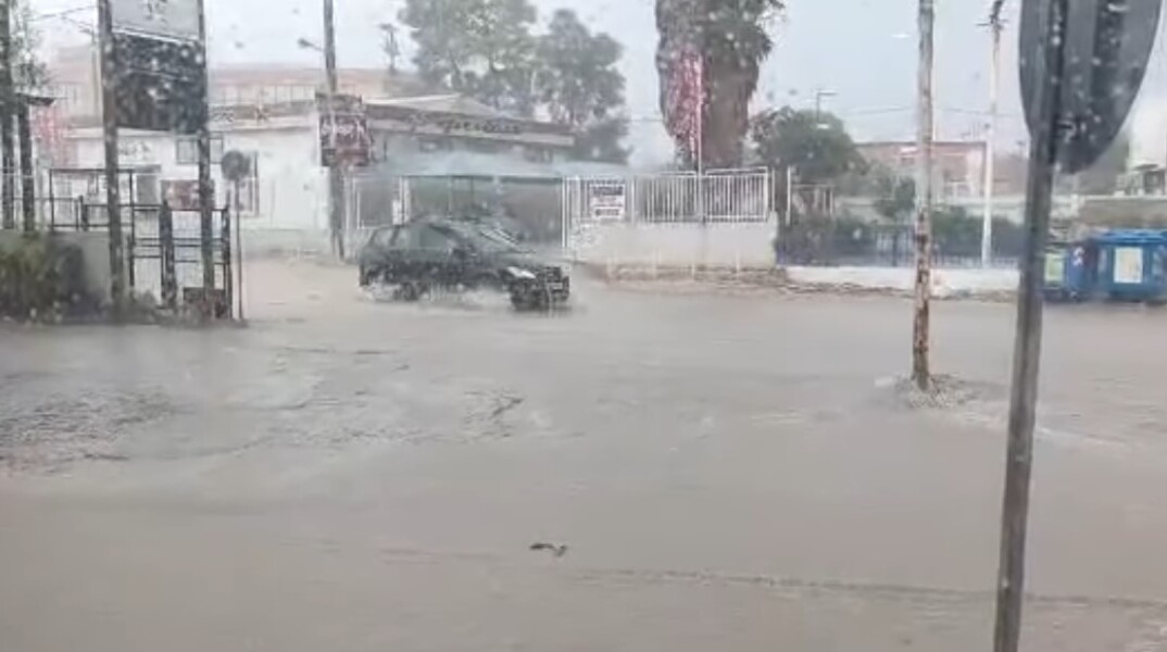 Αυτοκίνητο διέρχεται από πλημμυρισμένο δρόμο στο Μενίδι