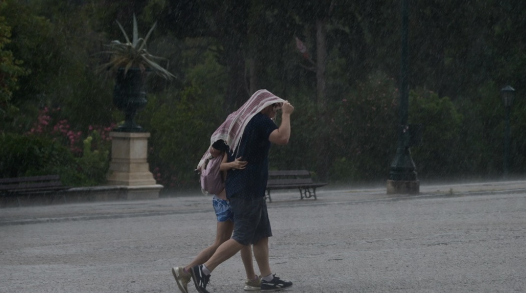 Καταιγίδα στην Αθήνα - Αγκαλιασμένοι πολίτες κάτω από ύφασμα