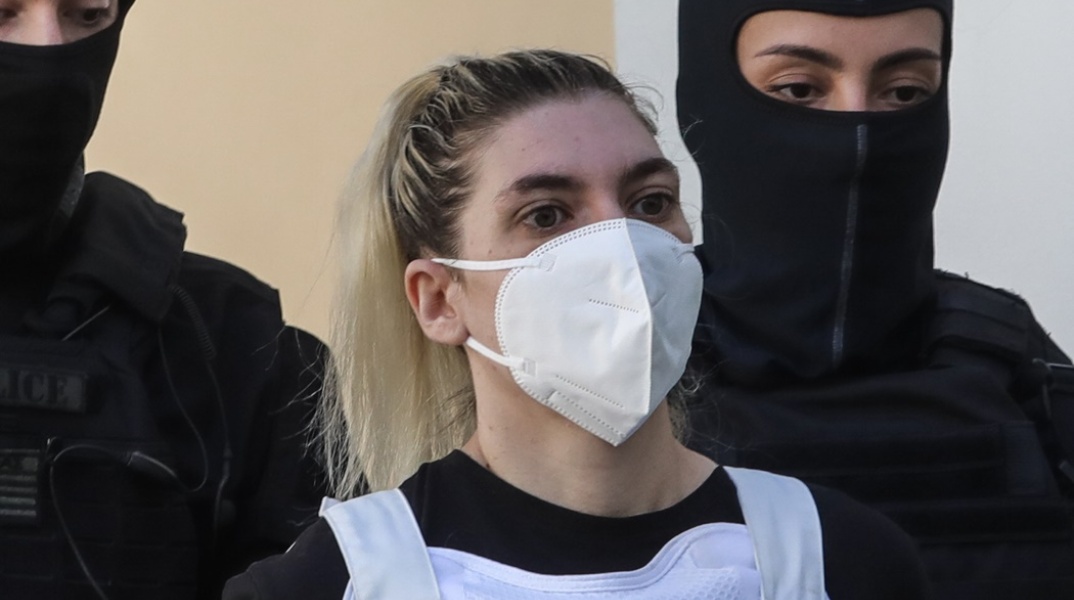 Η Ρούλα Πισπιρίγκου με μάσκα και αλεξίσφαιρο κατά τη μεταφορά της στον εισαγγελέα