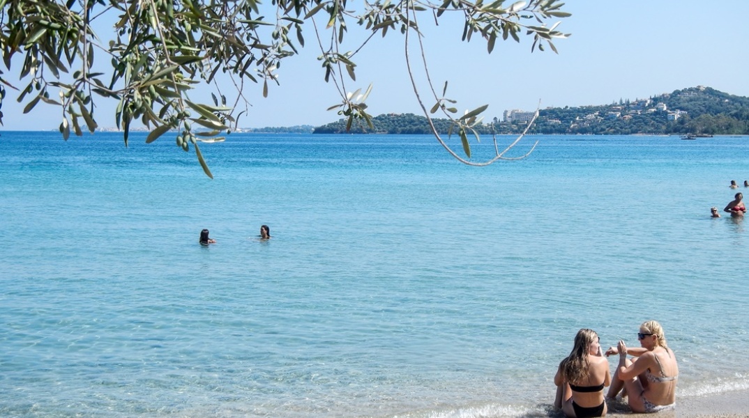 Γυναίκες με μαγιό στην ακροθαλασσιά απολαμβάνουν τον ήλιο