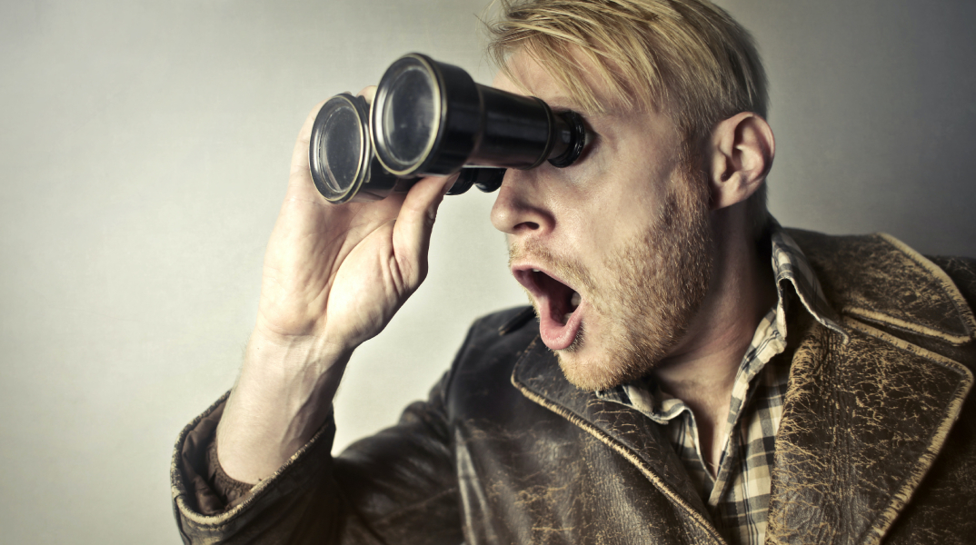 Άντρας σοκαρισμένος, κοιτάει μέσα από κυάλια