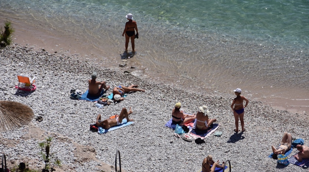 Πολίτες απολαμβάνουν το μπάνιο τους σε παραλία