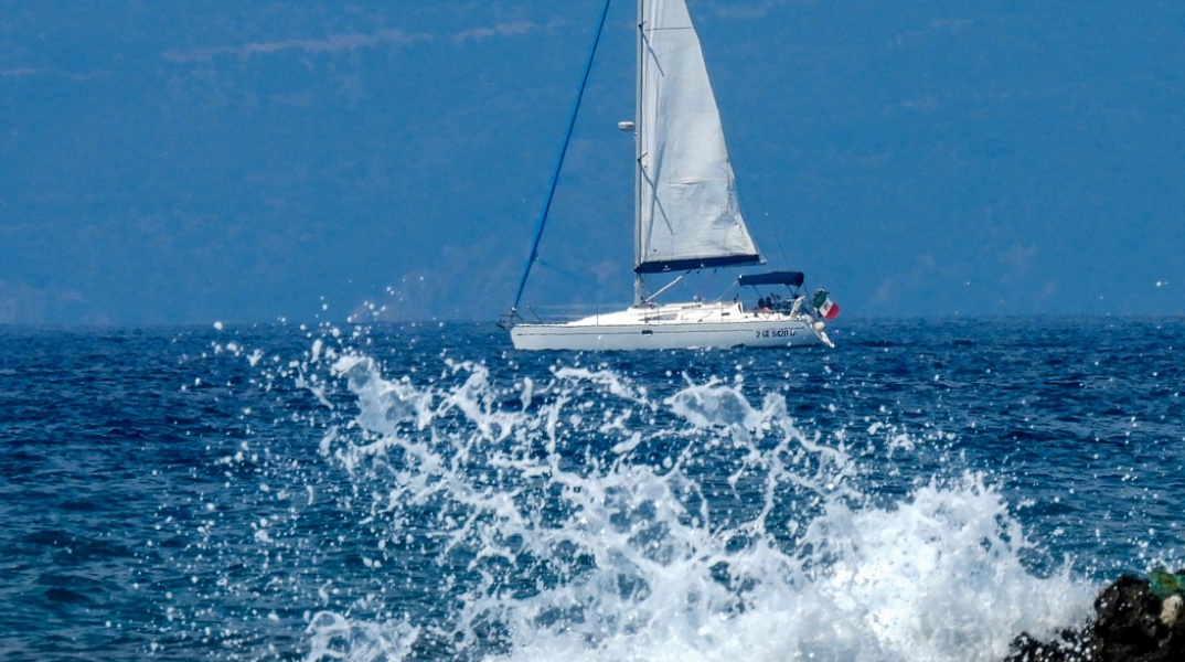 Καιρός: Ιστιοφόρο πίσω από εικόνα με κύμα της θάλασσας να σκάει στη στεριά