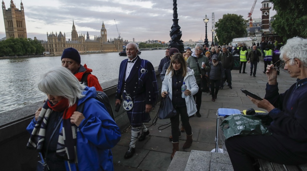 Πολίτες με νερά στα χέρια και με επίσημη ενδυμασία περιμένουν στην ουρά για το αντίο στη βασίλισσα Ελισάβετ