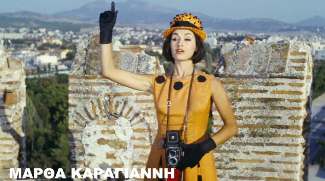 Η Μάρθα Καραγιάννη με φωτογραφική στα χέρια δίνει το σήμα για λήψη υψώνοντας το δεξί της χέρι