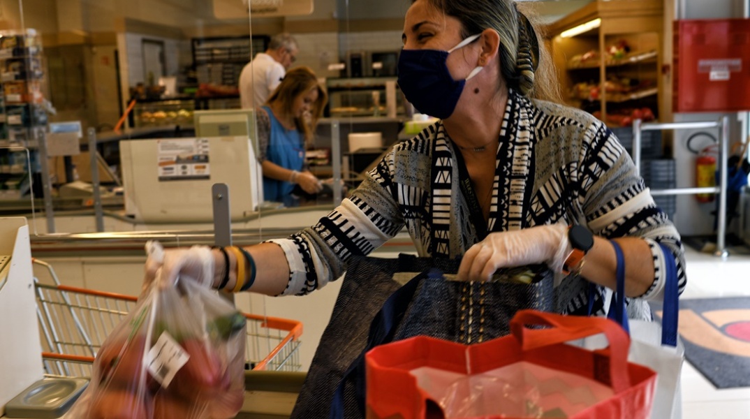 Γυναίκα με καλάθι αγορών σε σούπερ μάρκετ