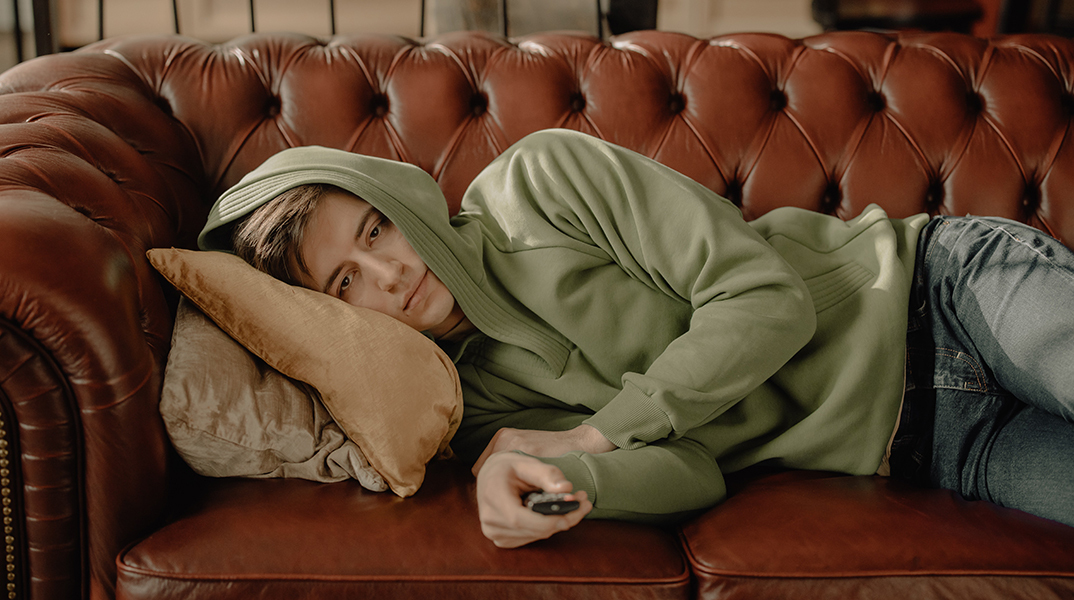 Άντρας στον καναπέ, βλέπει τηλεόραση