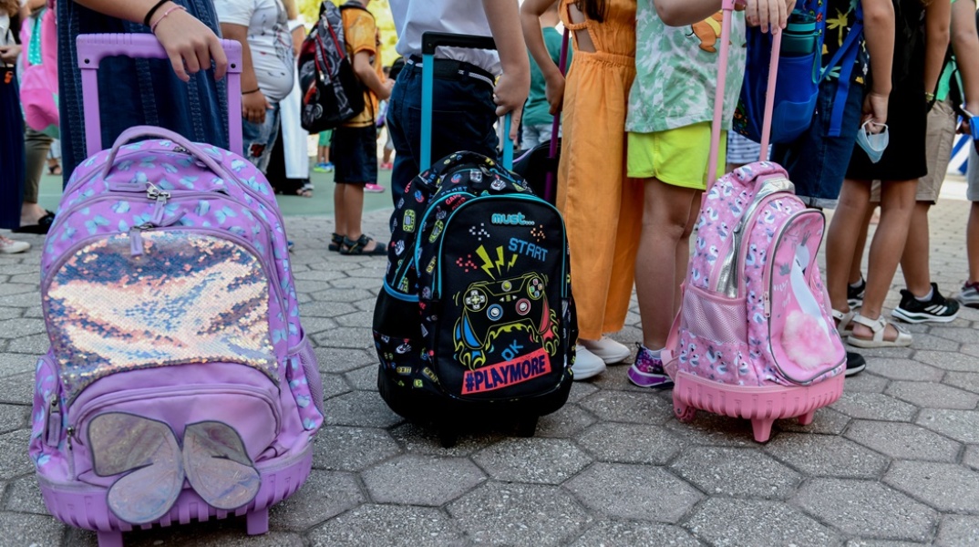 Μαθητές δημοτικού κρατούν τις σχολικές τους τσάντες