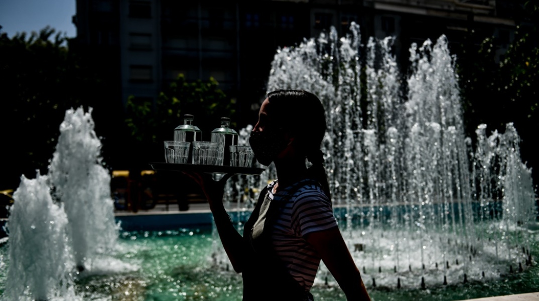 Η σκιά εργαζόμενης στον χώρο της εστίασης μπροστά από σιντριβάνι