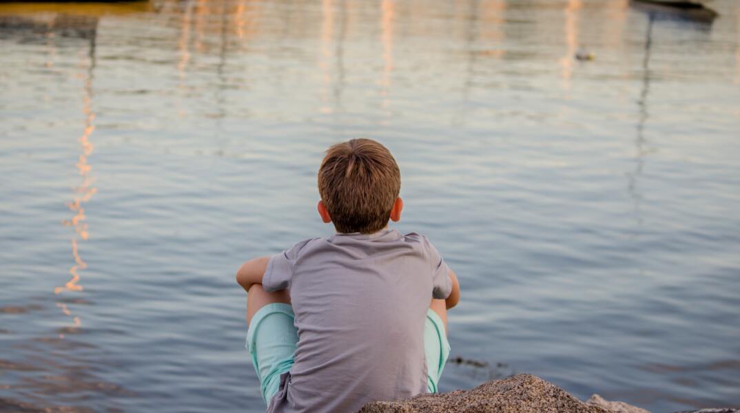 Παιδί κοιτά προς τη θάλασσα