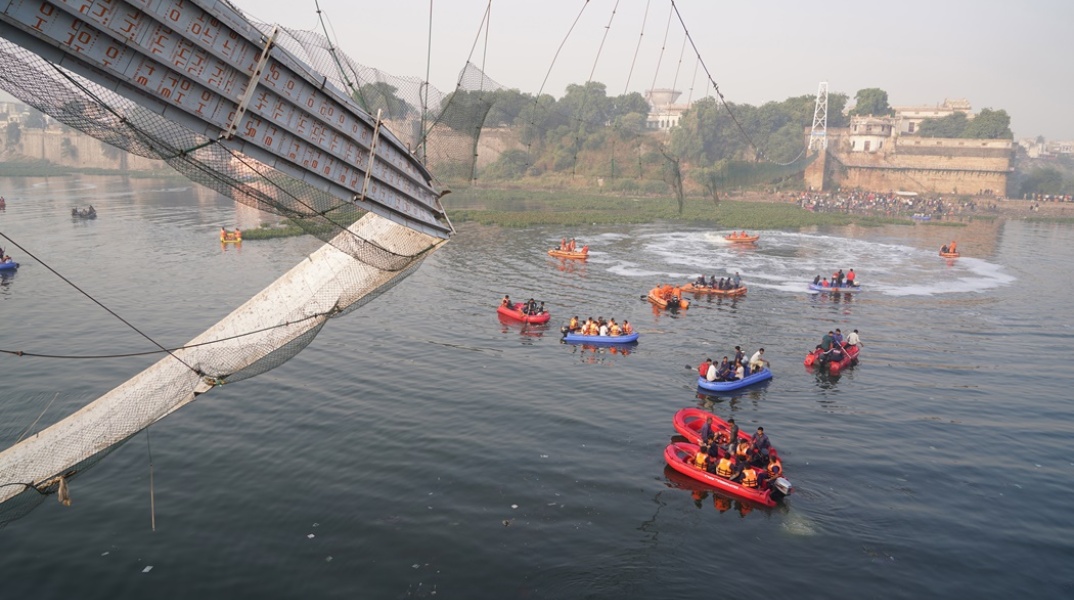 Διασώστες στο ποτάμι όπου κατέρρευσε η κρεμαστή γέφυρα
