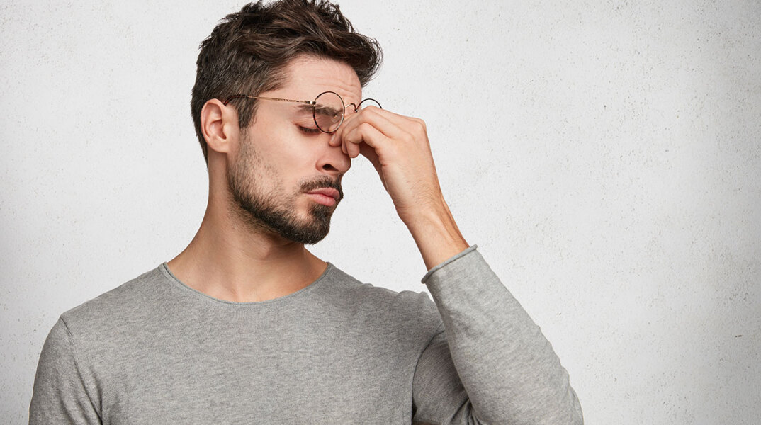 Άντρας τρίβει τα μάτια του