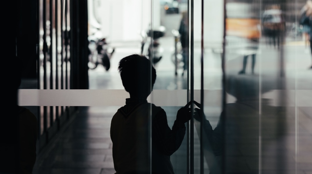 Ανήλικος πίσω από πόρτα κοιτά προς τον δρόμο