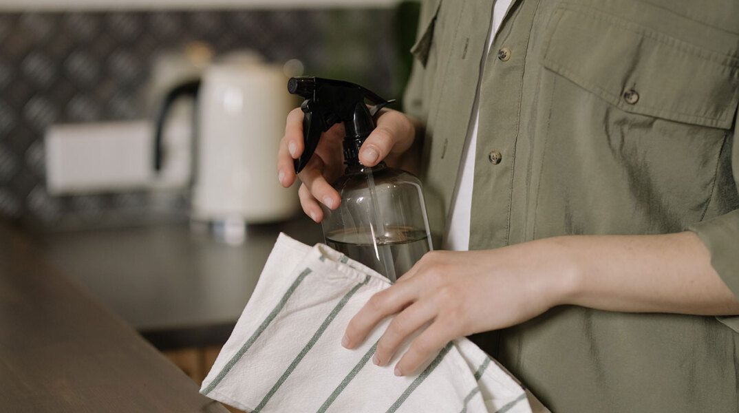 Γυναίκα κρατάει σπρέι και πανί