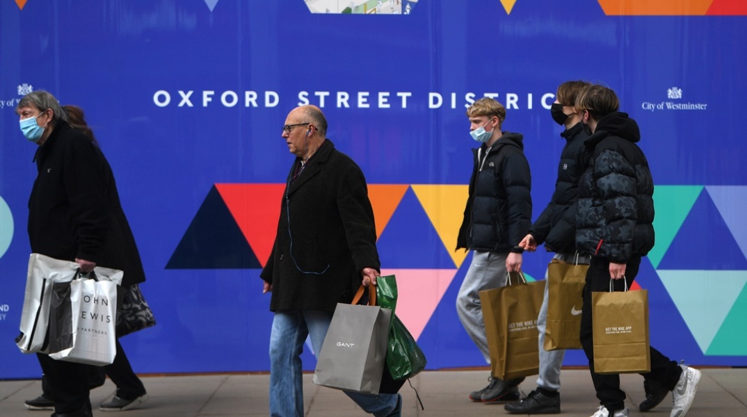 Πολίτες σε δρόμο της Βρετανίας με τσάντες από τις αγορές τους