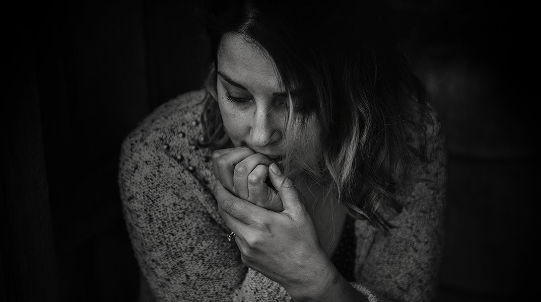 Ασπρόμαυρη φωτογραφία με γυναίκα που τρώει τα νύχια της από το Στρες