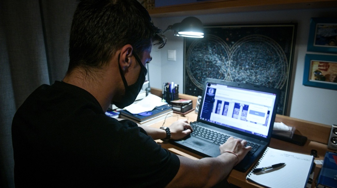 Φοιτητής με λάπτοπ και μάσκα κατά τη διάρκεια του lockdown