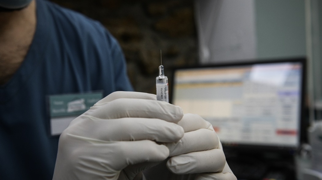 Φαρμακοποιός ετοιμάζεται να κάνει το αντιγριπικό εμβόλιο