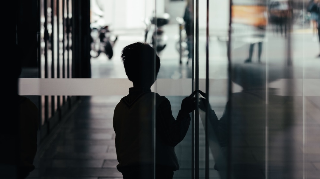 Αγόρι σε σκοτεινό διάδρομο κοιτά προς την έξοδο