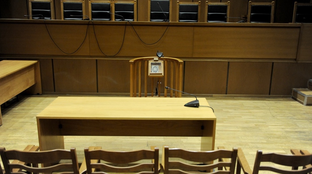 Αίθουσα δικαστηρίου χωρίς κόσμο με κενά έδρανα