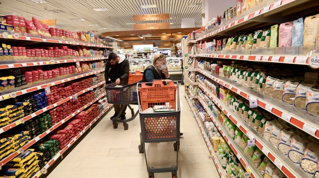 Καταναλωτές σε σούπερ μάρκετ αγοράζουν προϊόντα από το καλάθι του νοικοκυριού