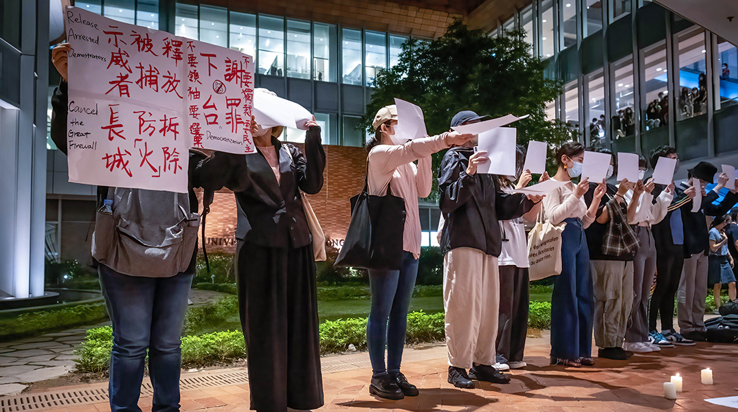 Διαδηλωτές στην Κίνα κρατούν λευκά χαρτιά κατά τη διάρκεια της διαδήλωσης ενάντια στη λογοκρισία των μηδενικών πολιτικών Covid-19