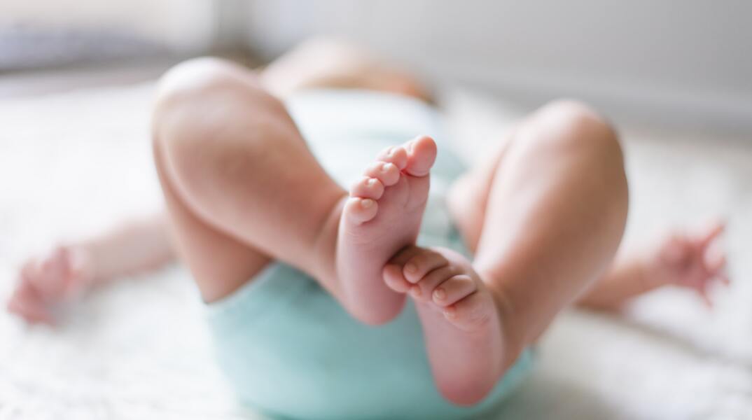 Ξαπλωμένο μωρό - Φαίνονται οι πατούσες του και τα ακάλυπτα ποδαράκια του