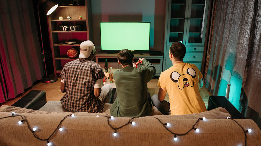 Τρία άτομα παίζουν video games. 
