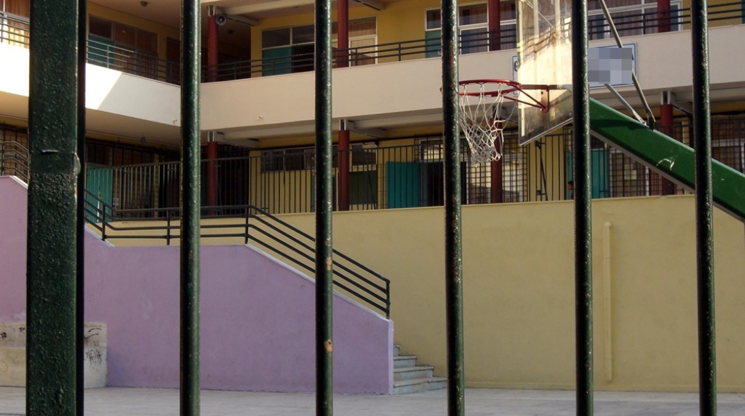Είσοδος σχολείου στο οποίο διακρίνεται το προαύλιο και η μπασκέτα