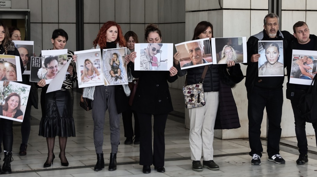 Συγγενείς θυμάτων της πύρινης τραγωδίας στο Μάτι κρατούν φωτογραφίες των νεκρών έξω από το δικαστήριο