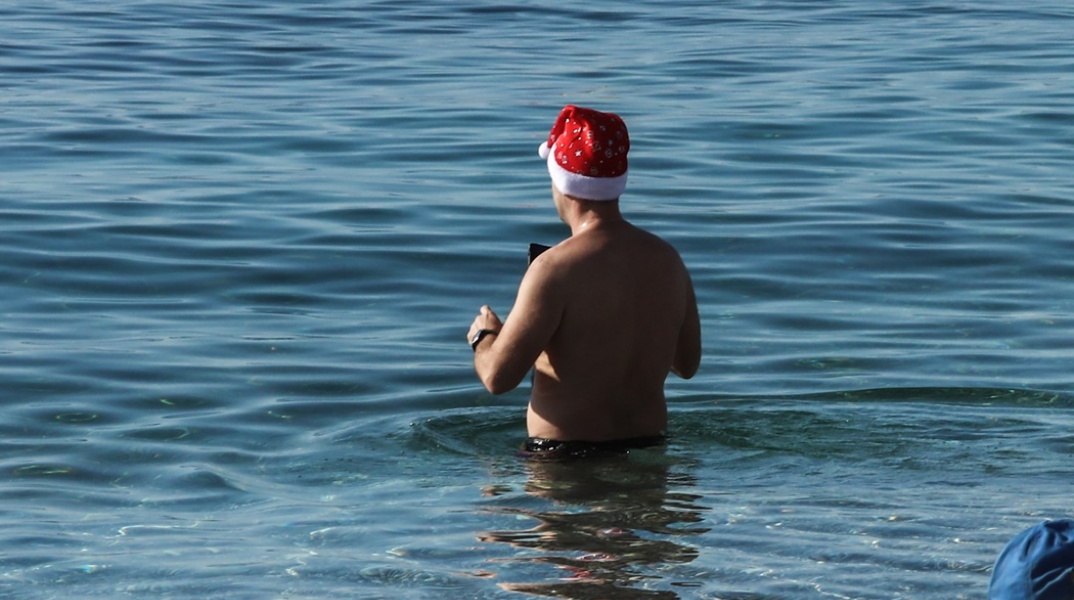 Καιρός για θάλασσα για άνδρα στην Αττική - Με τον σκούφο του Άη Βασίλη βουτά στα νερά