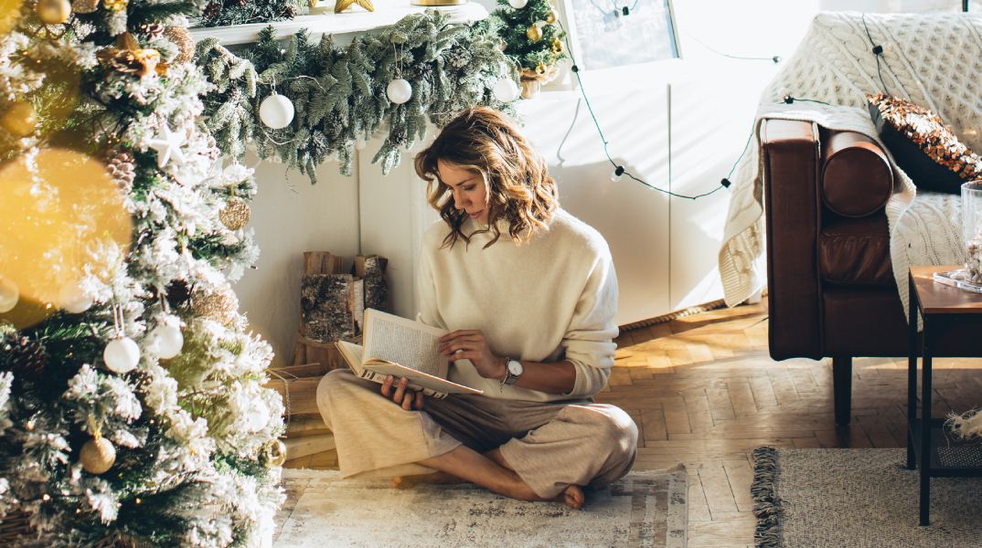 Γυναίκα που διβάζει δίπλα στο χριστουγεννιάτικο δέντρο