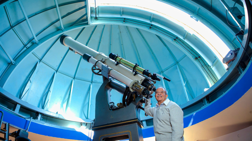 Holomon Station - Τηλεσκόπιο στον σταθμό και επιστήμονας που ποζάρει με χαμόγελο