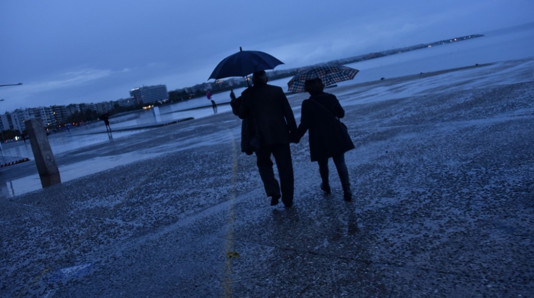 Άτομα με ομπρέλες στην παραλία της Θεσσαλονίκης