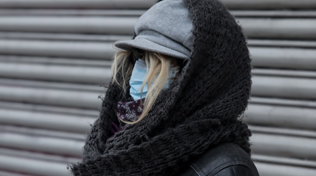 Γυναίκα με μάσκα προστασίας από τον κορωνοϊό, κουκούλα και κασκόλ