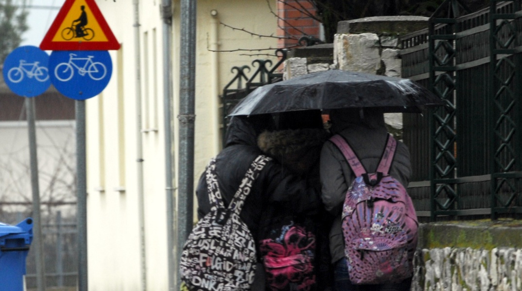 Τρεις μαθητές κάτω από μία ομπρέλα 