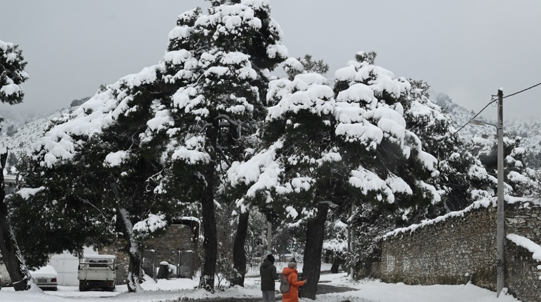 Κακοκαιρία - Ζευγάρι περπατά στα χιόνια