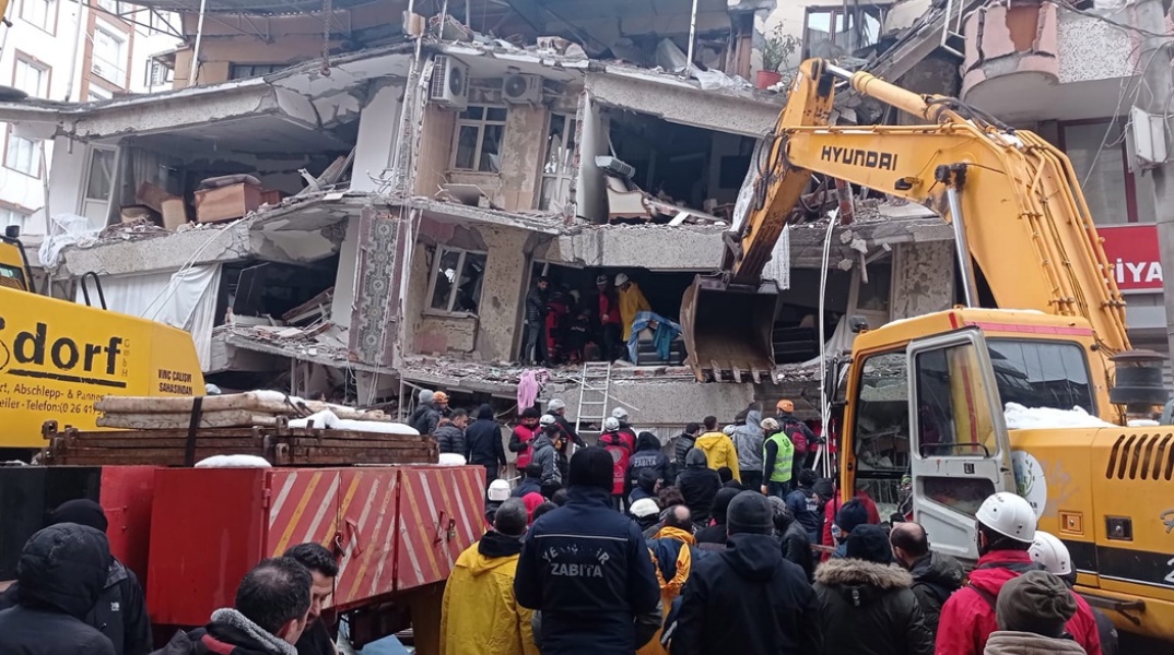 Διασώστες και πολίτες έξω από πολυκατοικία στην Τουρκία αναζητούν ζωντανούς στα χαλάσματα μετά τον φονικό σεισμό των 7,8 Ρίχτερ