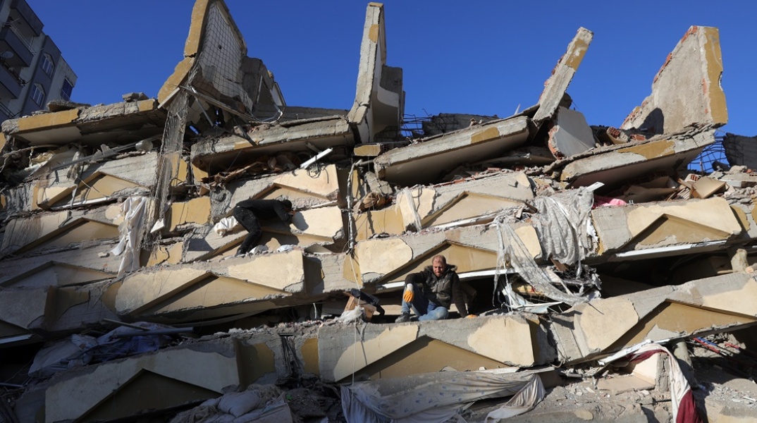Άνθρωποι πάνω στα ερείπια μετά τον σεισμό στην Τουρκία